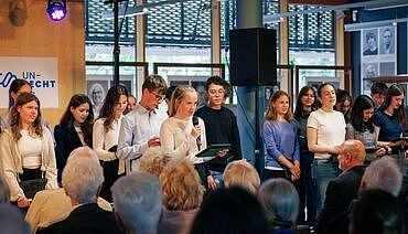 Ausschnitt aus Foto von szenischer Lesung durch mehrere Schüler/innen im Foyer des Generallandesarchivs Karlsruhe.