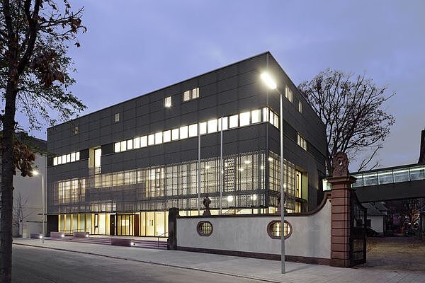 Foto des Neubaus des Generallandesarchivs Karlsruhe am Abend. Die Fenster des Gebäudes sind erleuchtet.