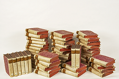 Das Bild zeigt mehrere Stapel von alten Büchern